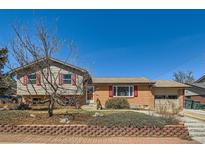 Charming home with brick accents, red shutters, and landscaped front yard at 11761 Keough Dr, Northglenn, CO 80233