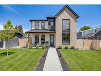 Charming two-story home featuring a modern exterior, well-manicured lawn, and inviting walkway to the front door at 2540 Jay St, Edgewater, CO 80214