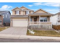 Two-story house with a beige exterior, front porch, and attached garage at 13735 Steele Ct, Thornton, CO 80602