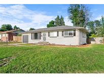 Charming single-story home with a well-maintained lawn, garage, and a classic design at 2996 S Sheridan Blvd, Denver, CO 80227