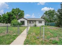Charming single-story home featuring a well-maintained yard and a classic white exterior at 1001 Victor St, Aurora, CO 80011
