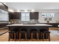 Spacious kitchen island with a white countertop and seating, complemented by sleek dark cabinetry and modern fixtures at 467 Harrison St, Denver, CO 80206