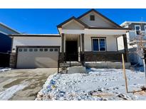 Two-story house with attached garage and snowy front yard at 9661 Ceylon St, Commerce City, CO 80022