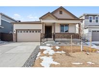 New construction home with a two-car garage and front porch at 9661 Ceylon St, Commerce City, CO 80022