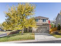 Two-story house with a beige exterior, attached garage, and landscaping at 11002 Glacier Park Cir, Parker, CO 80138