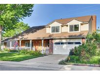 Charming two-story home with brick facade, covered porch, attached garage, and manicured lawn at 5622 E Weaver Cir, Centennial, CO 80111