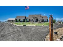 Charming home featuring mature landscaping, an American flag, and a circular driveway at 55610 E 40Th Ave, Strasburg, CO 80136