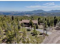 Stunning aerial view of a secluded home surrounded by lush forest and scenic mountain vistas at 32091 Black Widow Dr, Conifer, CO 80433