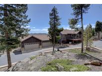 Charming multi-story home featuring a three car garage and mature landscaping at 32091 Black Widow Dr, Conifer, CO 80433