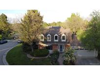 Charming brick home features a manicured front yard, attached garage, and classic architectural details at 10158 E Fair Cir, Englewood, CO 80111