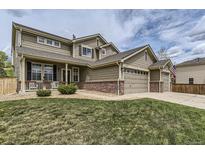 Charming two-story home featuring a covered front porch, three-car garage, and manicured lawn at 11895 Hitching Post Ct, Parker, CO 80134