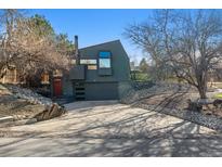 Modern two-story home with a red door, a garage, and unique window placements at 7770 S Estes St, Littleton, CO 80128