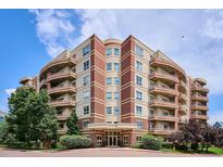 Beautiful condo building featuring brick accents, private balconies, and lush landscaping at 4875 S Monaco St # 303, Denver, CO 80237