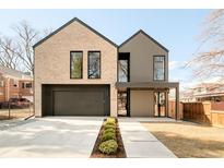 Striking modern home featuring a two-car garage, tan brick, gray siding, and manicured front yard at 633 Dexter St, Denver, CO 80220