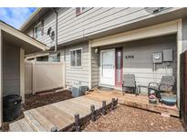 Inviting front porch with wooden deck and seating area at front entry at 8746 Carr Loop, Arvada, CO 80005