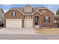 Charming two-story home featuring a stone facade, dormer window, and a two-car garage at 23635 E Del Norte Pl, Aurora, CO 80016
