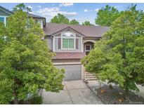 Charming home featuring gray siding, mature trees, and a two-car garage at 1441 S Ulster St, Denver, CO 80231