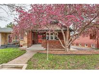 Charming red brick home with blossoming tree and inviting front yard at 1640 Harrison St, Denver, CO 80206