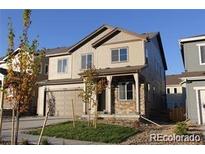 Charming two-story home with stone accents, covered porch, and a two-car garage at 15305 W 93Rd Ave, Arvada, CO 80007