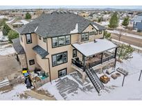 Spacious two-story home features a large deck, stone accents, and a well-manicured yard in a suburban neighborhood at 6985 Fallon Cir, Castle Rock, CO 80104
