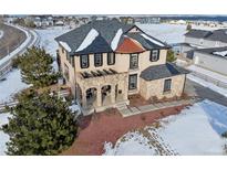 Beautiful two-story home featuring a stone porch, manicured landscaping, and a charming exterior at 6985 Fallon Cir, Castle Rock, CO 80104
