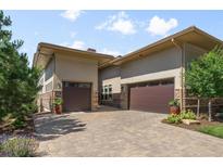 Elegant home exterior featuring a brick driveway and two-car garage at 10243 Spring Green Dr, Englewood, CO 80112