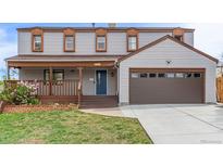 Charming two-story home with a covered front porch and attached two-car garage, perfect for Gathering living at 4808 S Ward Way, Morrison, CO 80465