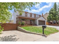 Charming two-story home with a covered front porch, a two-car garage, a well-manicured lawn and a driveway at 4808 S Ward Way, Morrison, CO 80465