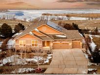 Stunning aerial view of a house with lake views and solar panels at 26631 E Arbor Dr, Aurora, CO 80016