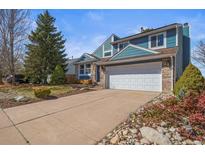 Charming two-story home featuring a brick-accented facade, complemented by a well-manicured lawn and mature trees at 8815 W Quarto Cir, Littleton, CO 80128
