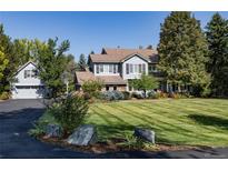 Charming two-story home with lush green lawn, mature trees, and a circular driveway at 4483 W Cottonwood Pl, Littleton, CO 80123