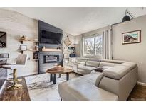 Comfortable living room featuring a modern fireplace, flat screen TV, and light gray leather sectional sofa at 4063 S Quintero Way, Aurora, CO 80013