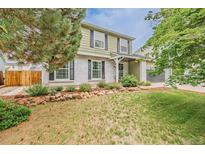 Charming two-story home featuring a well-maintained lawn and attractive landscaping at 16051 E Alabama Dr, Aurora, CO 80017
