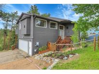 Inviting home featuring a charming front yard, rustic fence and private driveway at 30273 Conifer Rd, Evergreen, CO 80439