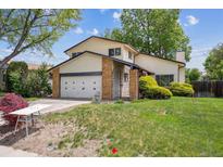 Charming two-story home with a well-maintained lawn, attached garage, and inviting curb appeal on a sunny day at 8552 Gray Ct, Arvada, CO 80003