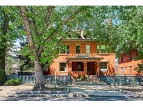 Charming brick home featuring a welcoming front porch and well-maintained blue fence at 1401 N Franklin St # 1, Denver, CO 80218