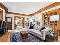 Inviting living room features hardwood floors, wood trim, built-in shelving, and a large, comfortable sofa at 1401 N Franklin St # 1, Denver, CO 80218