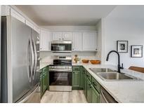 Modern kitchen featuring stainless steel appliances and stylish two-tone cabinetry at 2642 Devonshire Ct, Denver, CO 80229