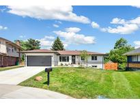 Charming one-story home with a well-maintained lawn, mature trees, and an attached garage in a suburban neighborhood at 1354 S Wright St, Lakewood, CO 80228
