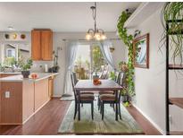 Cozy dining area with hardwood floors, a rustic table set, and a charming view to an outdoor patio at 3312 Meadow Ave, Broomfield, CO 80020