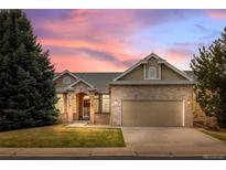 Charming brick home with a well-maintained lawn and attached two-car garage at dusk at 5322 Shetland Ct, Highlands Ranch, CO 80130