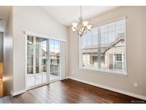 Bright dining area with hardwood floors, sliding glass door to balcony, and chandelier at 11932 W Long Cir # 201, Littleton, CO 80127