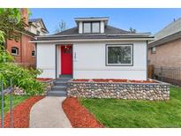 Charming home with a vibrant red door, complemented by a stone accent wall and a well-maintained front yard at 2767 W 38Th Ave, Denver, CO 80211