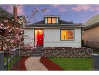 Charming home featuring a red front door, river rock landscaping, and blooming tree at 2767 W 38Th Ave, Denver, CO 80211