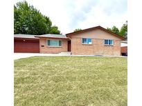 Charming brick home featuring a well-maintained lawn and attached garage at 2203 S Harlan St, Denver, CO 80227