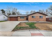 Charming brick home featuring an attached garage and a well-manicured front yard at 2203 S Harlan St, Denver, CO 80227