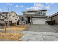 Charming two-story home with gray siding, stone accents, and a well-maintained front yard at 9692 Cathay St, Commerce City, CO 80022