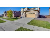 Beautiful two-story home with a spacious driveway and well-manicured lawn at 9373 Pitkin St, Commerce City, CO 80022