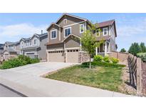 Charming two-story home with a two-car garage, inviting curb appeal, and well-manicured lawn at 15100 Gaylord St, Thornton, CO 80602