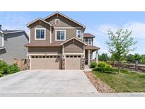 Charming two-story home with a three-car garage and manicured lawn in a suburban neighborhood at 15100 Gaylord St, Thornton, CO 80602